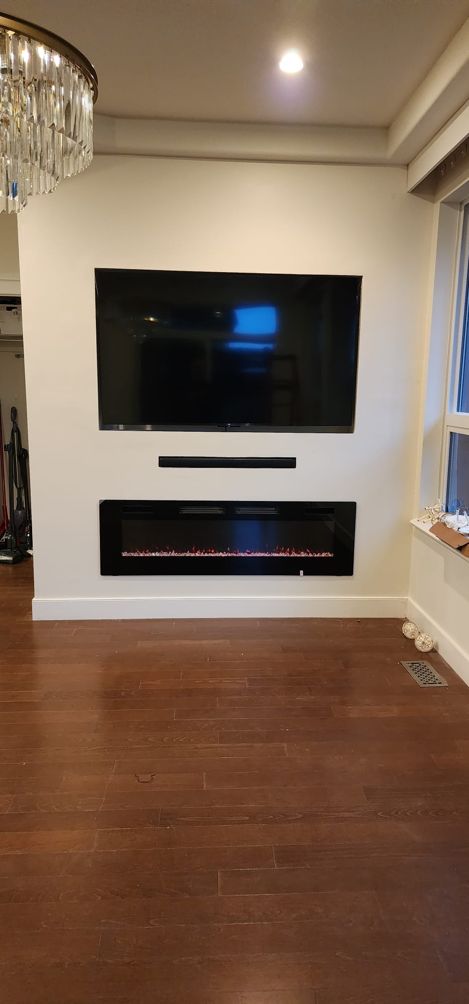 Feature wall after — mounted TV, soundbar and built-in electric fireplace