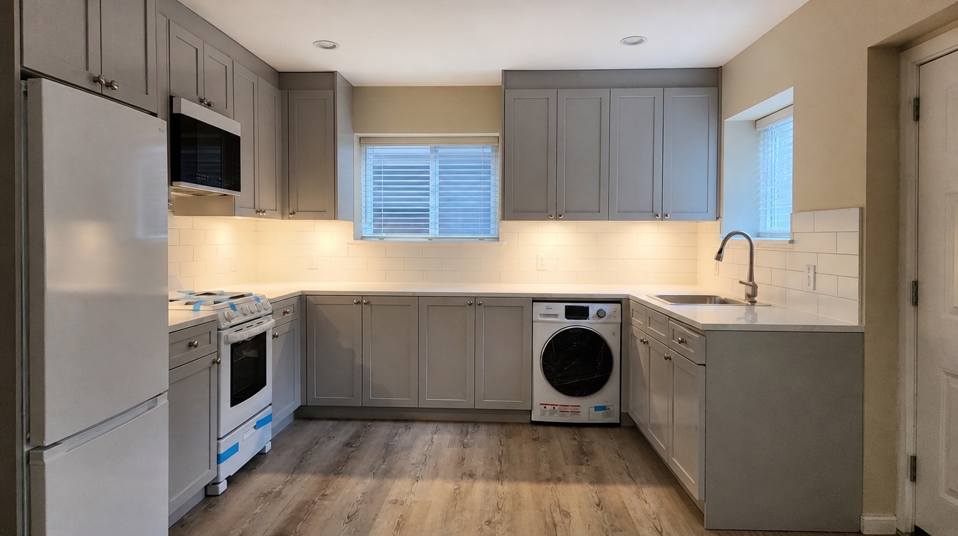 Finished basement kitchen — grey shaker cabinets, quartz counters and new appliances