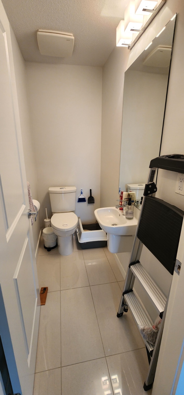 Powder room before renovation — dated tile and fixtures