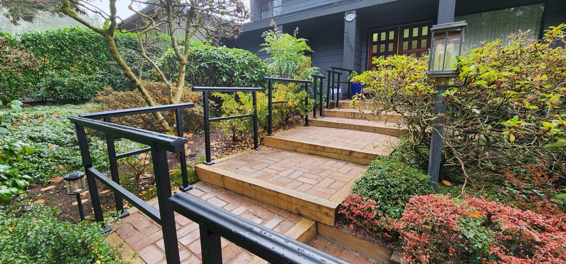 Paver steps after — finished with black metal handrails