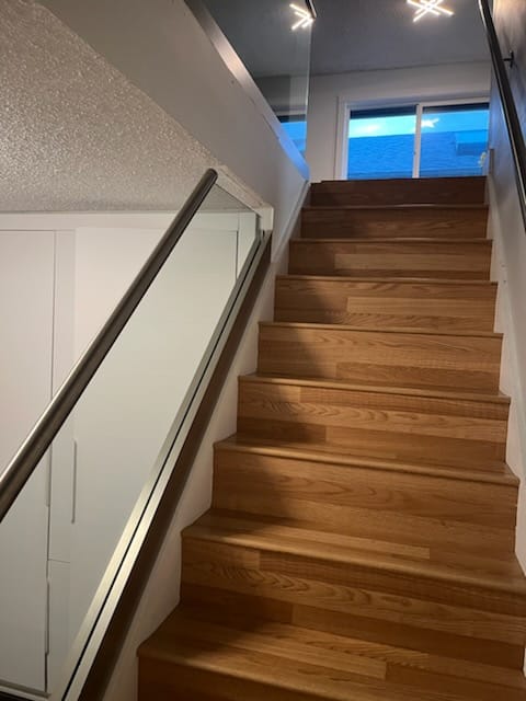 Stairwell after glass railing installation — frameless glass panel railing