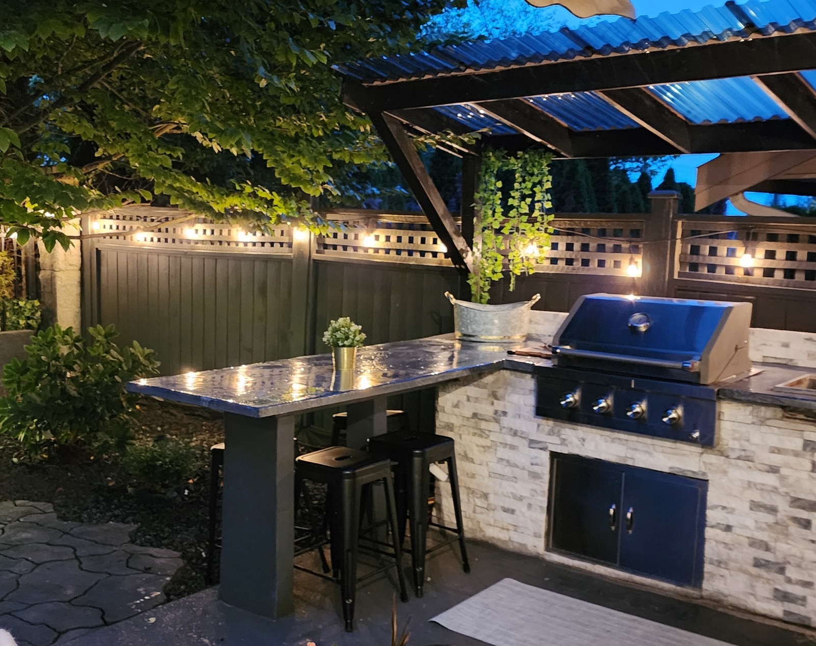 Backyard after outdoor kitchen build — stone bar with built-in grill