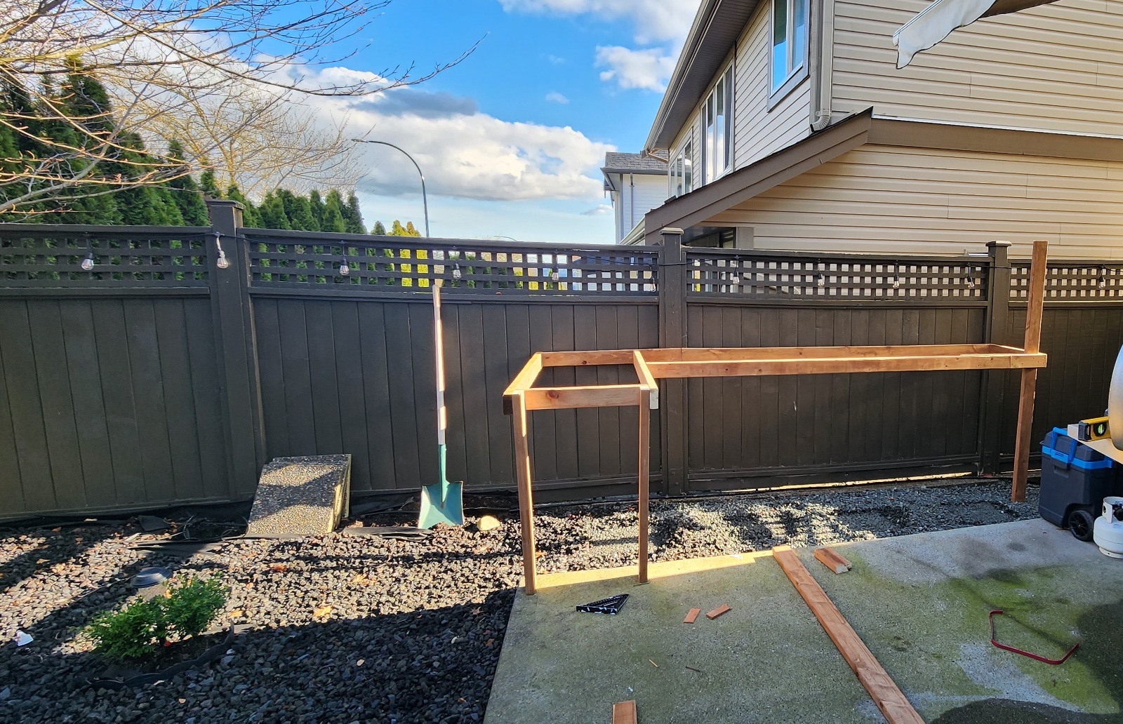 Backyard before outdoor kitchen build — bare patio and fence